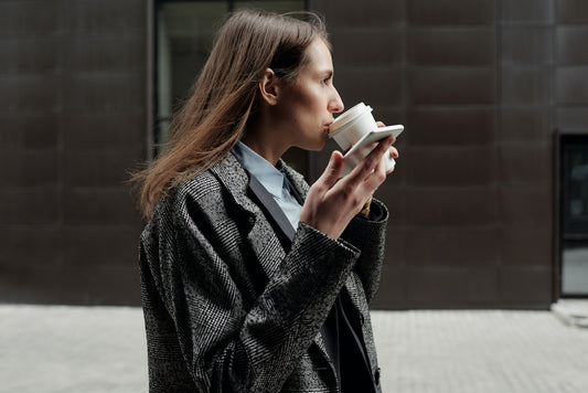 A woman drinking a cup of coffee on the street
