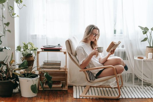 A woman holding a cup of tea with CBD oil