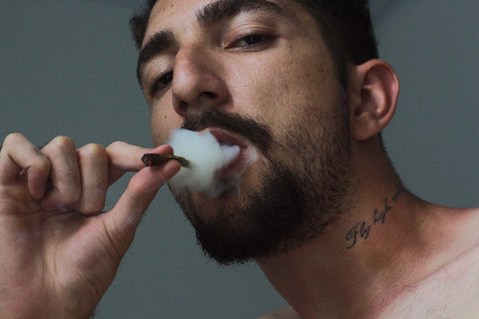A man smoking a CBD joint with weed
