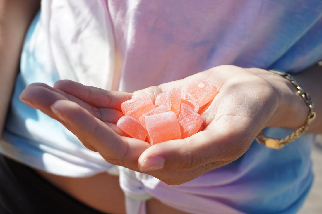 a woman holding cherry CBD gummies in her hand